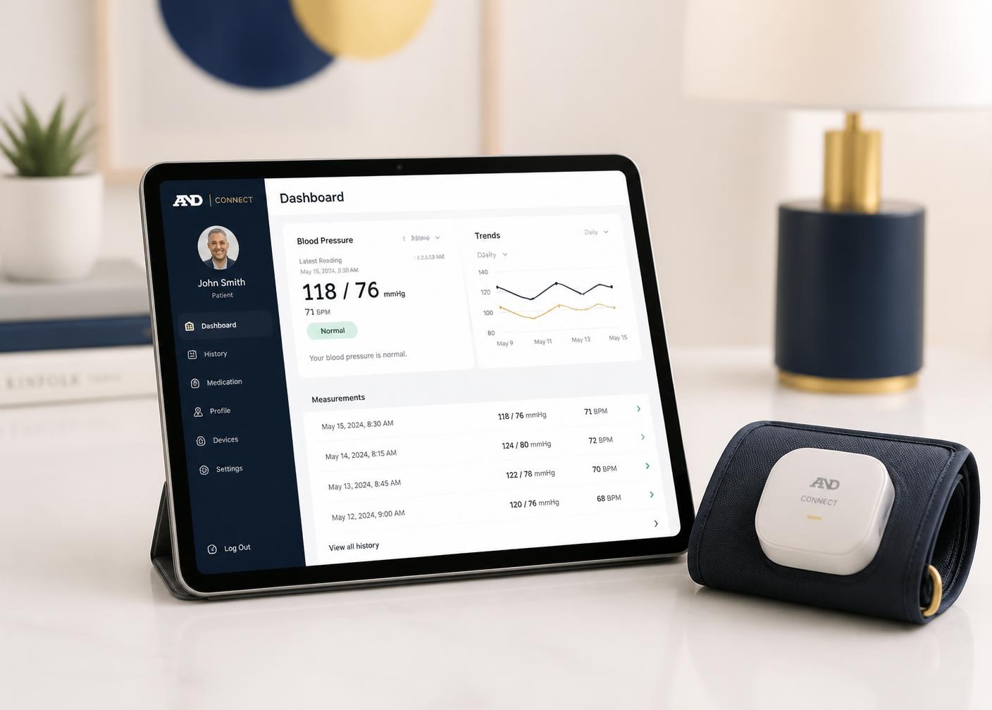 A tablet displaying a remote patient monitoring dashboard beside a connected blood pressure cuff